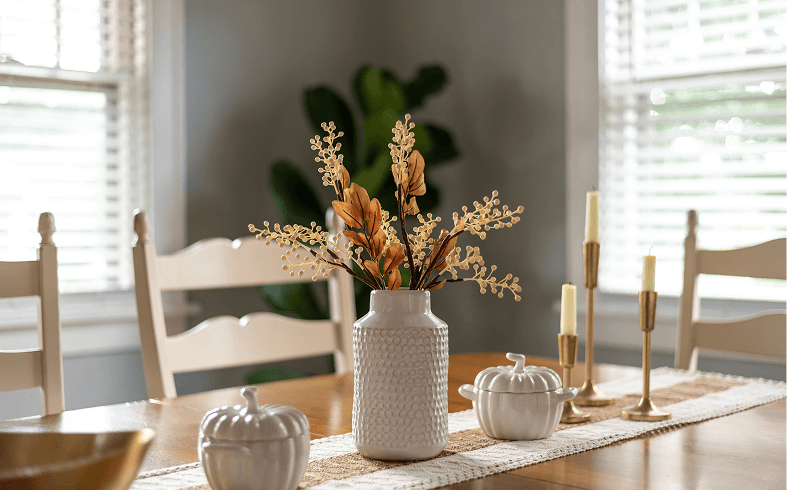 Dining table with vase and decor items.