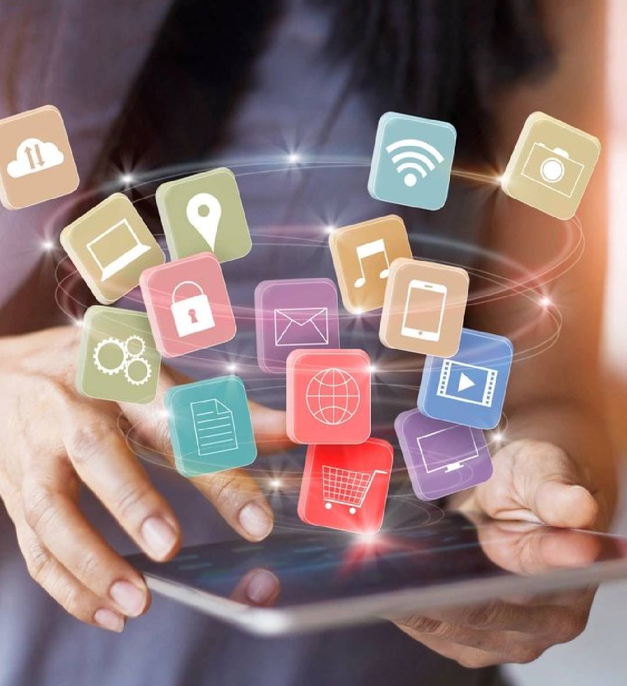 Person interacting with floating digital app icons above a tablet.