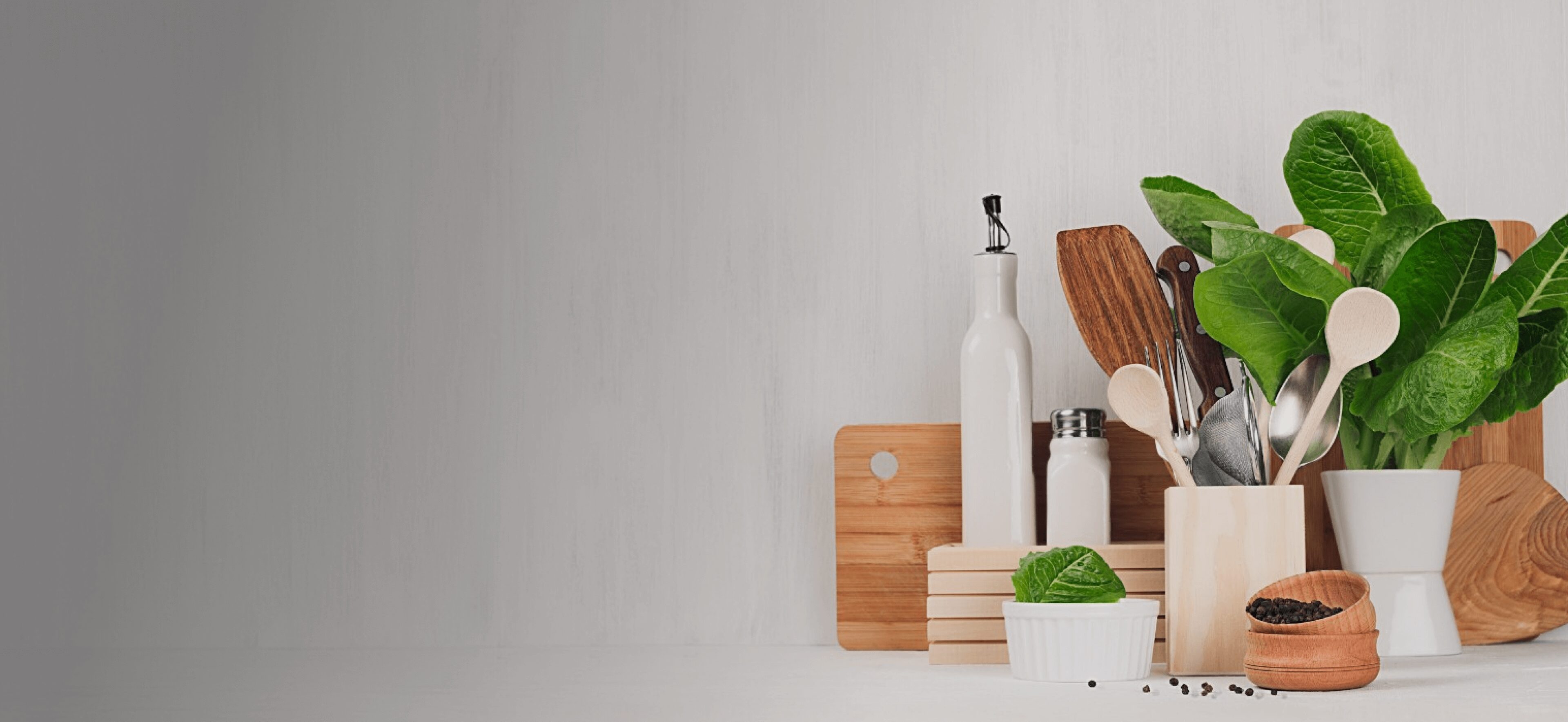 Kitchen utensils with herbs and wooden boards.